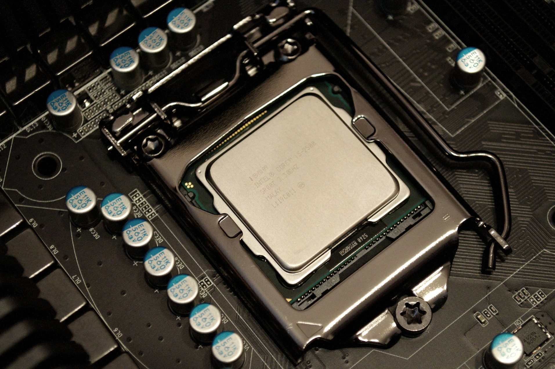 Close-up of a CPU mounted on a motherboard, surrounded by capacitors.